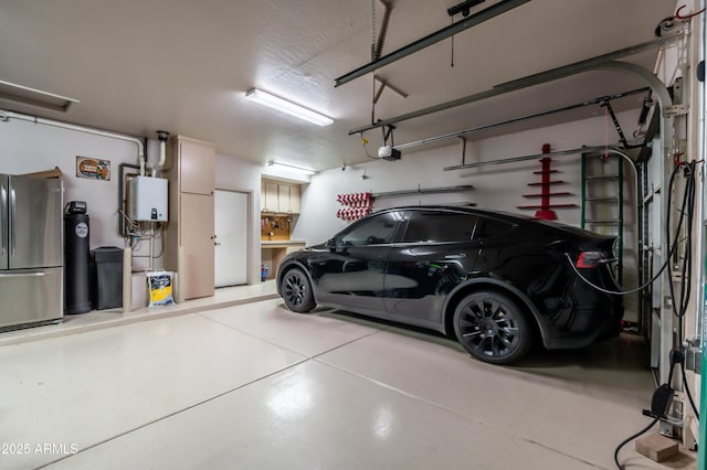 garage with a garage door opener and freestanding refrigerator