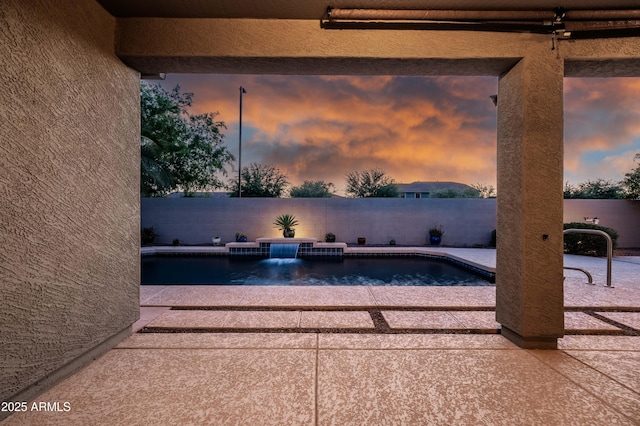 pool at dusk featuring a patio, a fenced backyard, and a fenced in pool