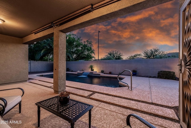patio terrace at dusk featuring a fenced in pool and a fenced backyard