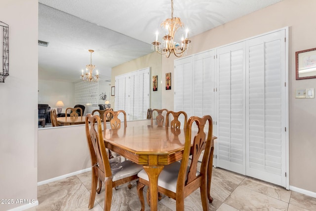 dining space with a notable chandelier and a textured ceiling