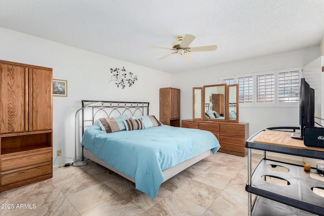 bedroom featuring ceiling fan and a textured ceiling