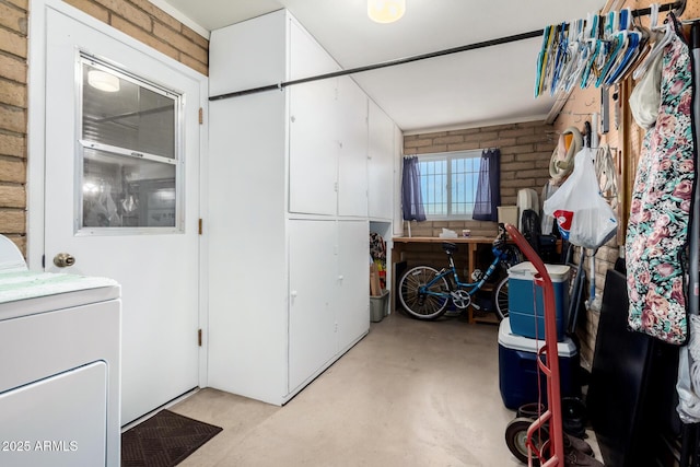 washroom with washer / dryer and brick wall