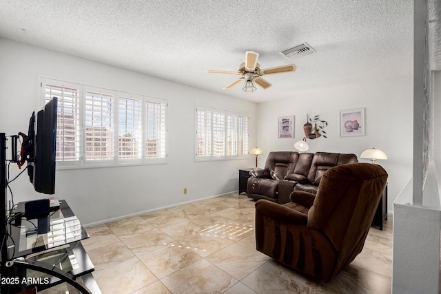 living room featuring ceiling fan and a textured ceiling