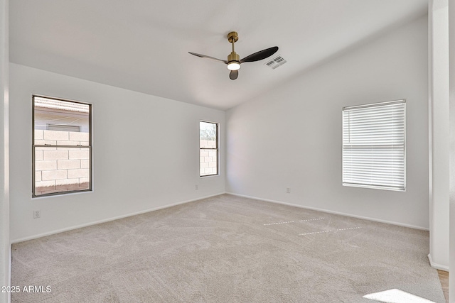 empty room with visible vents, a ceiling fan, baseboards, light colored carpet, and vaulted ceiling