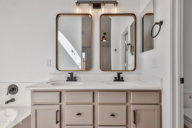 bathroom with double vanity, toilet, a bathtub, and a sink