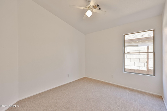 spare room featuring baseboards, light colored carpet, a ceiling fan, and vaulted ceiling