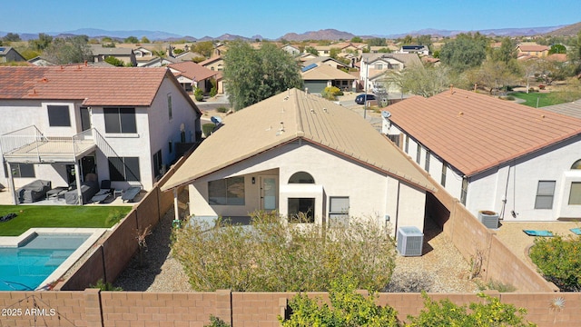 back of property with a mountain view, a residential view, and a fenced backyard