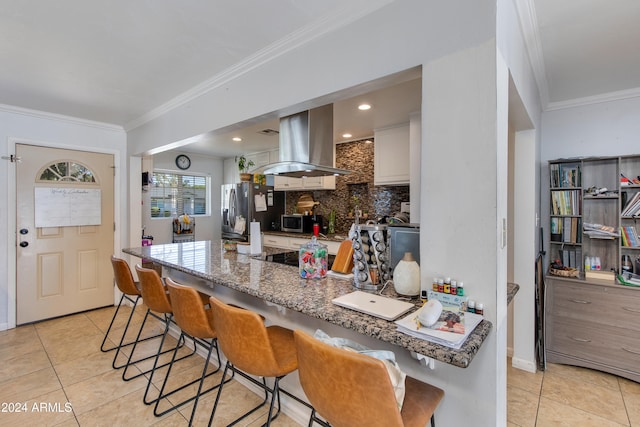 kitchen with island exhaust hood, kitchen peninsula, stainless steel appliances, white cabinets, and crown molding