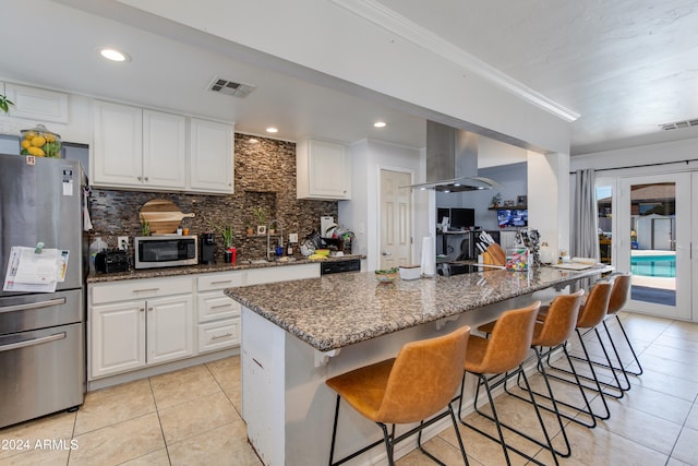 kitchen featuring white cabinetry, island exhaust hood, stainless steel appliances, and crown molding