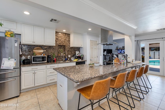 7830 N 17th Ave, Phoenix, AZ 85021 - kitchen with stainless steel appliances, island range hood, light tile patterned floors, tasteful backsplash, and a breakfast bar area
