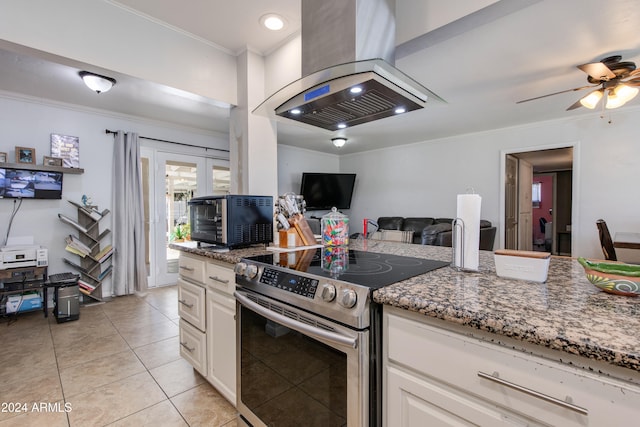 kitchen with stone counters, island exhaust hood, white cabinetry, stainless steel electric range oven, and crown molding