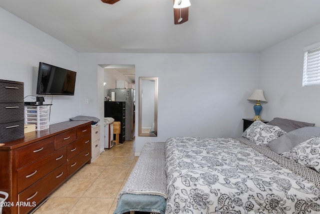 bedroom featuring ceiling fan, light tile patterned floors, and stainless steel fridge