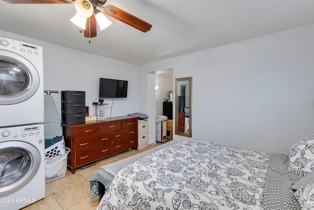 tiled bedroom featuring stacked washer / dryer and ceiling fan