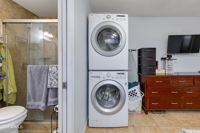 laundry room featuring stacked washer and dryer and light tile patterned floors