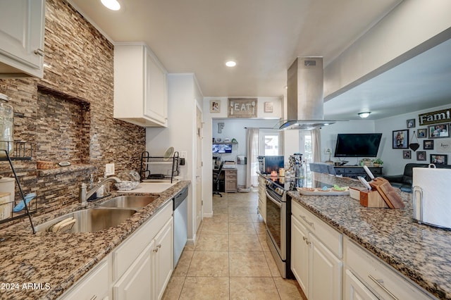 kitchen featuring white cabinets, appliances with stainless steel finishes, island range hood, stone counters, and sink