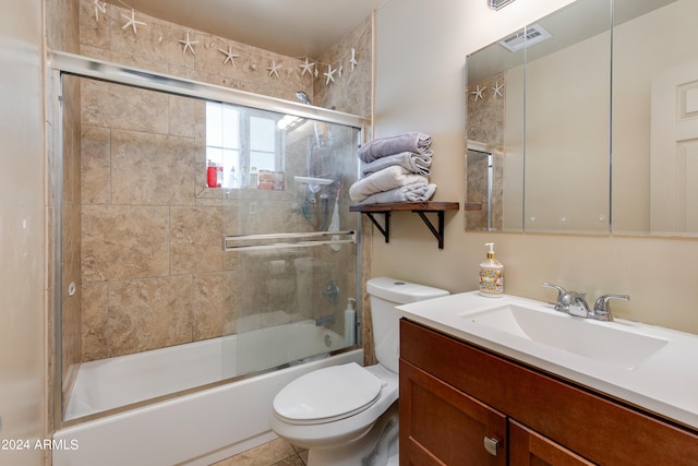 full bathroom with toilet, vanity, tile patterned floors, and shower / bath combination with glass door