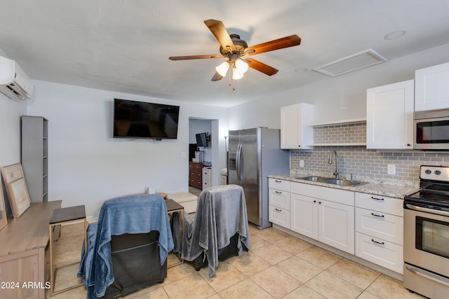 kitchen featuring an AC wall unit, sink, appliances with stainless steel finishes, and white cabinetry