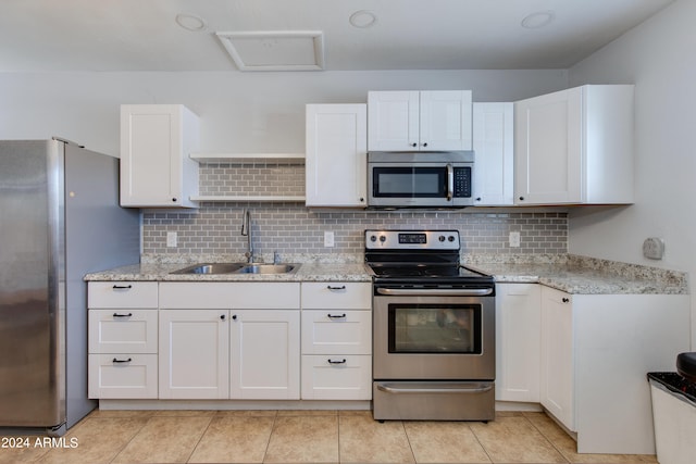 kitchen featuring white cabinetry, tasteful backsplash, stainless steel appliances, and sink