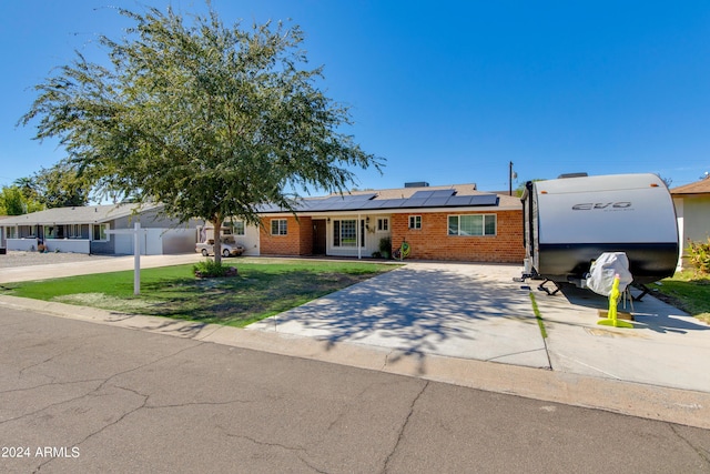 7830 N 17th Ave, Phoenix, AZ 85021 - ranch-style house with brick siding, roof mounted solar panels, and concrete driveway