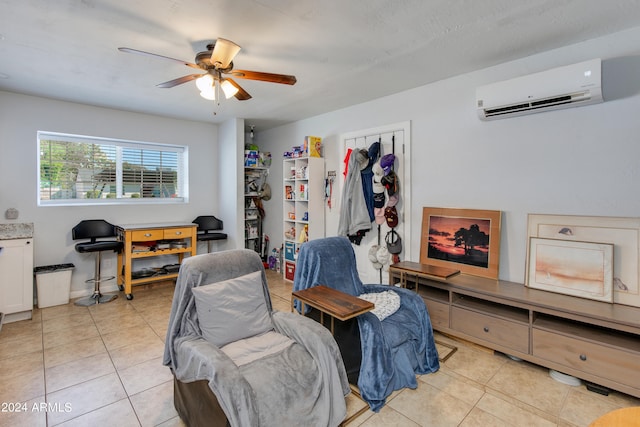 sitting room with an AC wall unit, light tile patterned floors, and ceiling fan