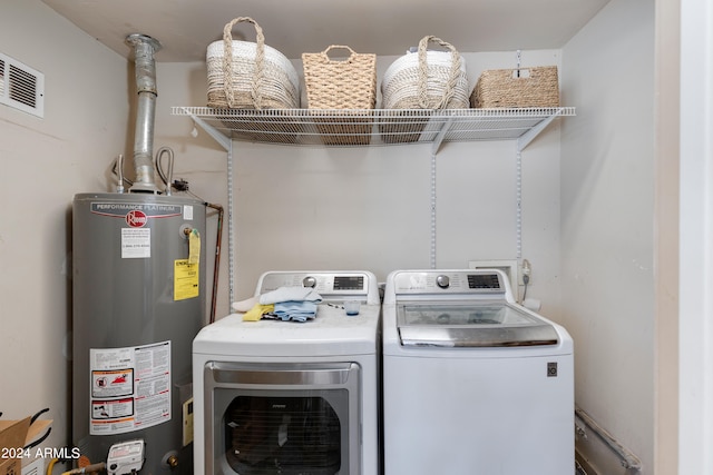 washroom with water heater and washing machine and clothes dryer