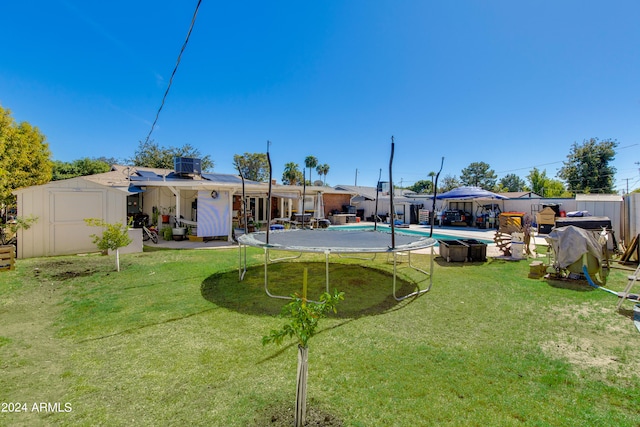 view of yard featuring a patio, a storage shed, central AC, and a fenced in pool