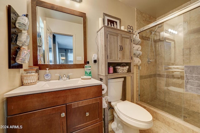 bathroom featuring vanity, toilet, tile patterned floors, and an enclosed shower