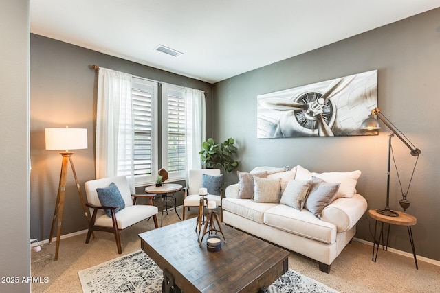 living area with visible vents, baseboards, and carpet floors