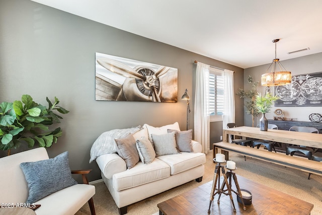 carpeted living room featuring a notable chandelier and visible vents