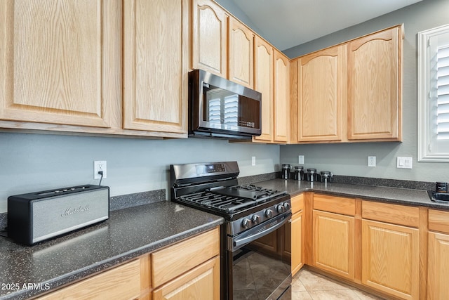 kitchen with stainless steel microwave, light tile patterned flooring, black range with gas stovetop, and light brown cabinets