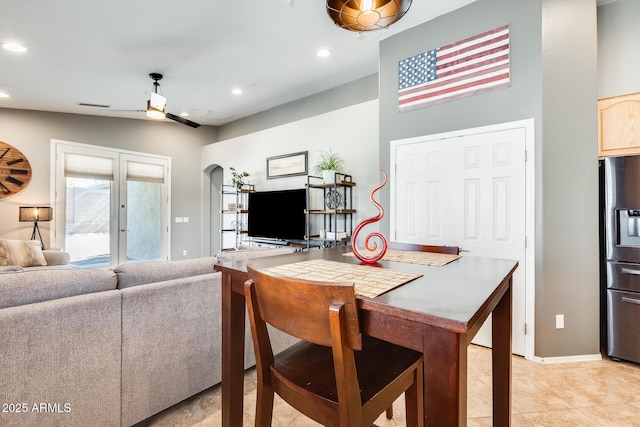 dining space with arched walkways, light tile patterned floors, baseboards, and recessed lighting