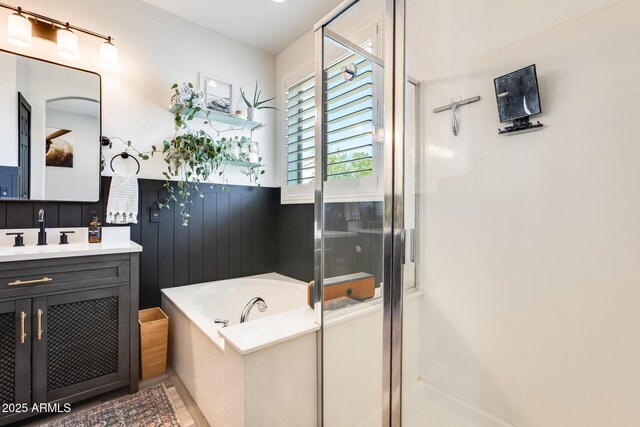 bathroom featuring a shower stall, vanity, and a garden tub