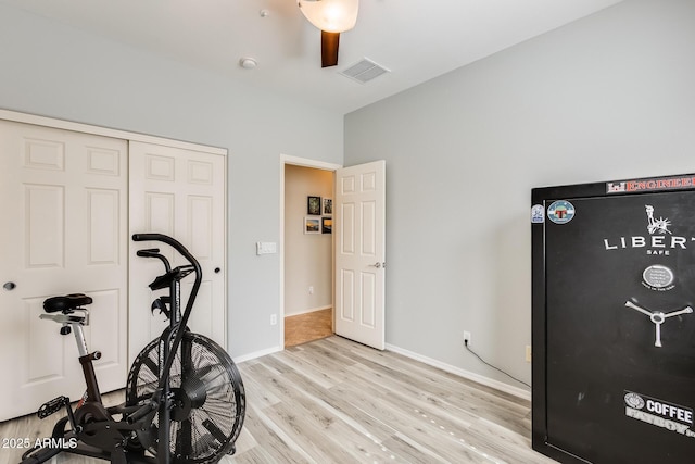 workout room featuring light wood finished floors, baseboards, and visible vents