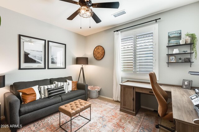 office area featuring light carpet, baseboards, a ceiling fan, and visible vents