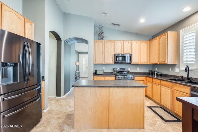 kitchen featuring a sink, dark countertops, appliances with stainless steel finishes, and light brown cabinets