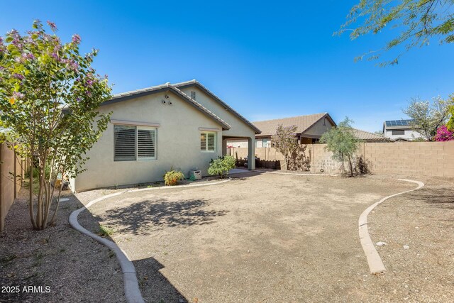 back of house featuring a patio, a fenced backyard, and stucco siding