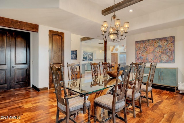 dining room with light wood-type flooring, a notable chandelier, and beamed ceiling