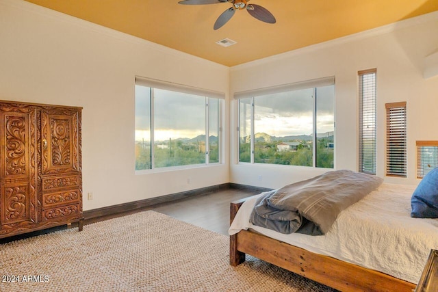 bedroom featuring ceiling fan, hardwood / wood-style flooring, and crown molding