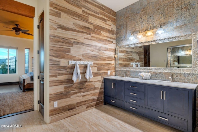 bathroom featuring wooden walls, vanity, and ceiling fan