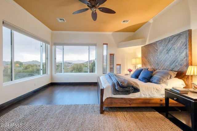 bedroom featuring ceiling fan, a mountain view, dark hardwood / wood-style floors, and crown molding