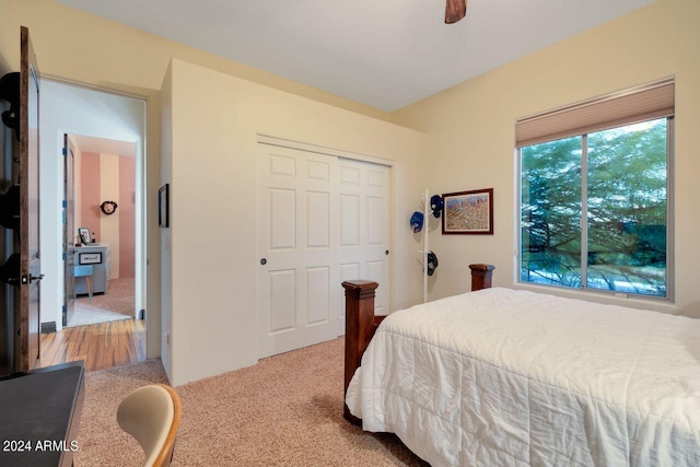 bedroom featuring ceiling fan, a closet, and light carpet