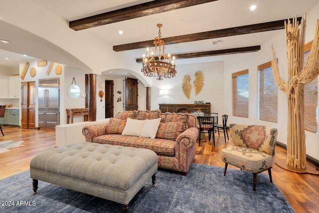 living room featuring beam ceiling, hardwood / wood-style floors, and a chandelier