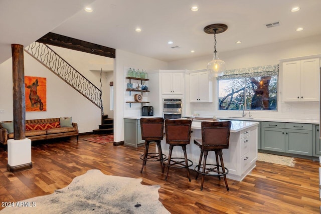 kitchen featuring sink, a kitchen bar, hardwood / wood-style floors, and a center island