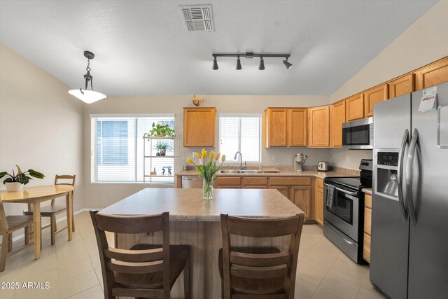 2221 E Union Hills Dr Unit 148, Phoenix, AZ 85024 - kitchen with appliances with stainless steel finishes, a sink, track lighting, light countertops, and a center island