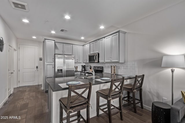 kitchen with dark countertops, visible vents, a peninsula, and appliances with stainless steel finishes