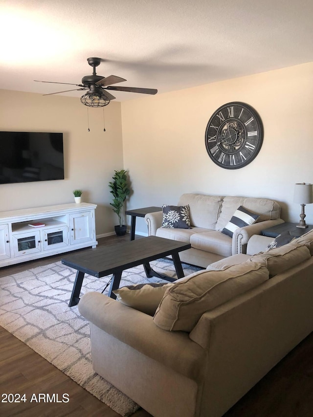 living room featuring ceiling fan and dark hardwood / wood-style floors