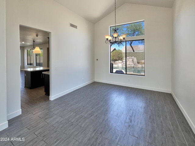 unfurnished dining area featuring a notable chandelier, lofted ceiling, and dark hardwood / wood-style floors