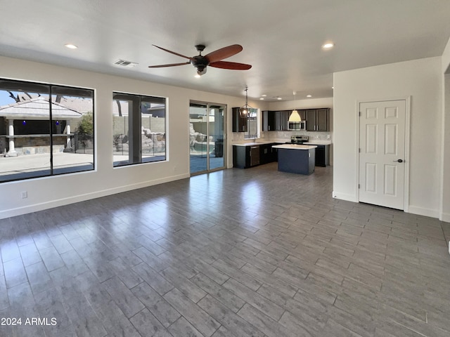 unfurnished living room with ceiling fan, hardwood / wood-style flooring, and sink