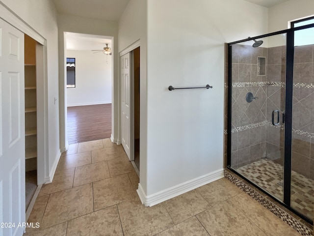 bathroom featuring wood-type flooring, ceiling fan, and a shower with door