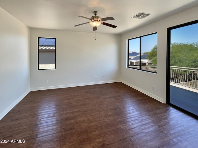 empty room with ceiling fan, dark hardwood / wood-style flooring, and a healthy amount of sunlight